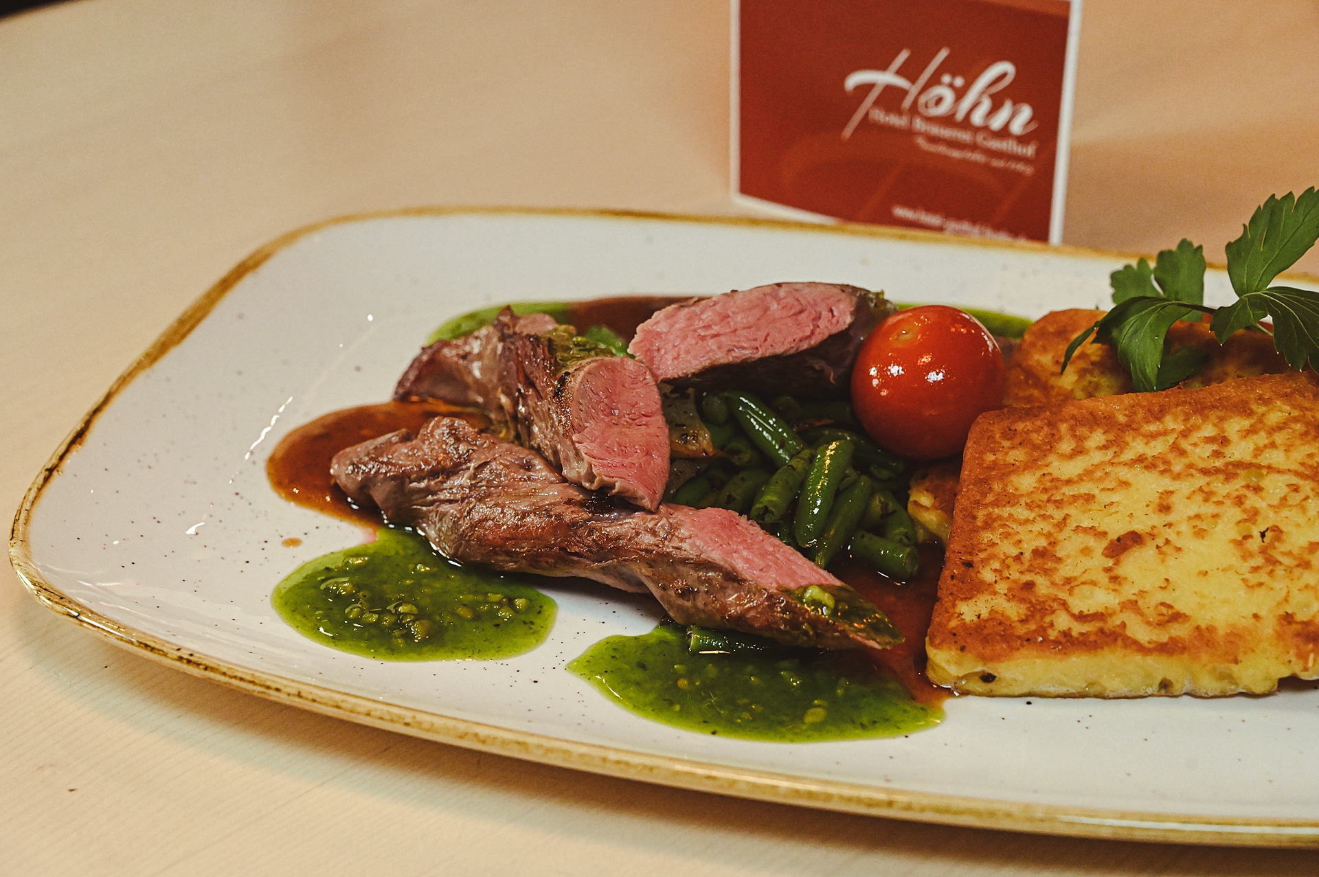Gebratenes Lammfilet mit kräftiger Rosmarinjus, dazu gebräunte Kartoffelterrine und Birnenbohnengemüse mit Bärlauchpesto